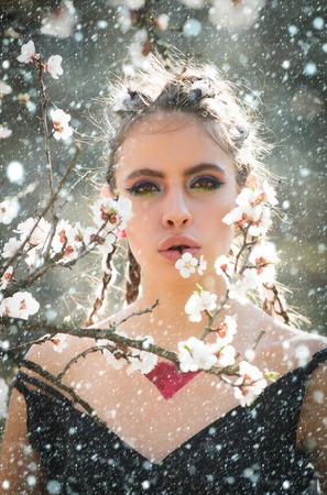 christmas new year snow concept woman in beautiful spring flower blossom in garden with fashion makeup on summer natural background, youth and healthの写真素材