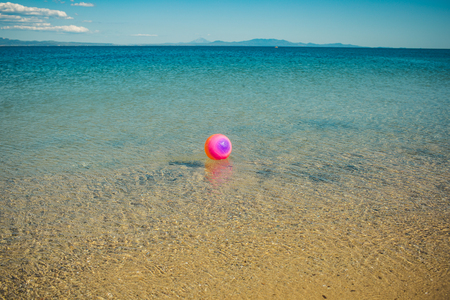 pink ball swim on sea or ocean water. summer activity and vacation. sport and game. childhood and relax.の写真素材