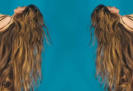 Girl with beautiful hair, look. Hairdresser salon and barber. Hair style and health. Beauty and fashion. Woman with long healthy hair on blue background, copy spaceの写真素材