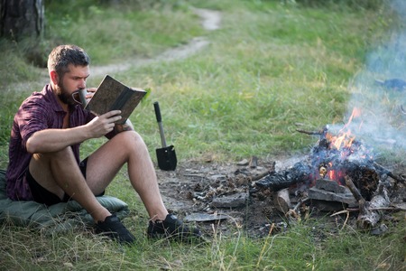 Sustainable education, environment concept. Camping, hiking, lifestyle. Man traveler read and drink...
