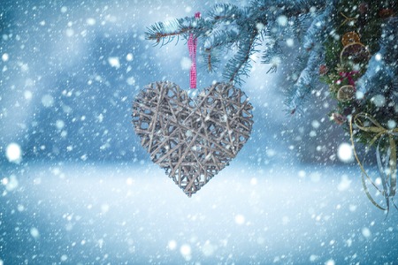 christmas new year snow concept new year and valentines day, heart decoration on christmas tree in winter snowy outdoor, copy space, holiday and party celebrationの写真素材