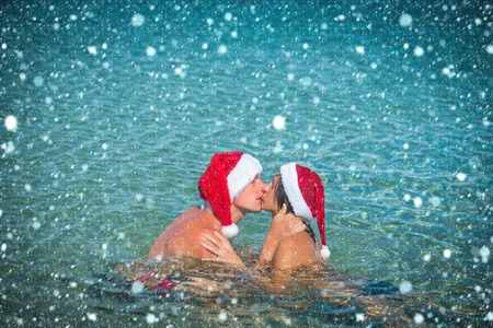 new year christmas snow concept Christmas couple in red at beach. Couple in love of happy man and...