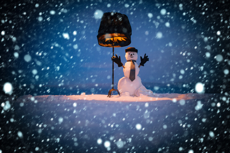 new year christmas snow concept New year snowman from snow in hat, gloves and tie. Happy holiday and celebration. Winter evening party. Snowman gentleman with black lamp. Christmas or xmas decoration.の写真素材