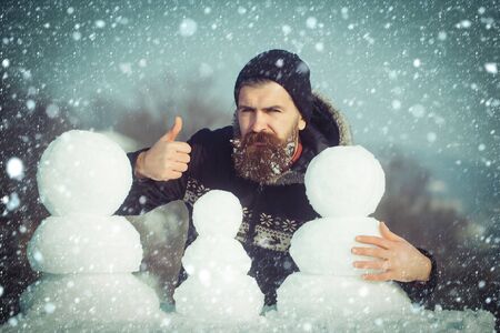 new year christmas snow concept Winter holiday vacation and xmas party celebration. Snowman family made of white snow New year guy on blue sky with snow figure. Christmas man long beard. Santa clausの写真素材