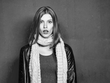 Young pretty woman or fashionable sexy girl with cute face and blonde hair in scarf and coat on pink background, copy spaceの写真素材