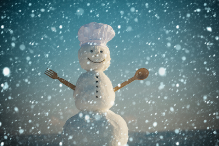 christmas and new year snow concept Snowman chef in winter with kitchen spoon. Xmas or christmas cooking. Happy holiday celebration. New year snowman in cook hat. Christmas food cooking.の写真素材
