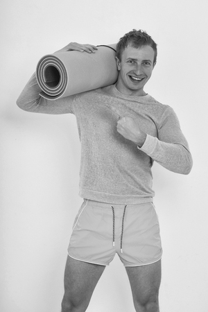 happy smiling handsome guy man with muscular torso and sexy body training in sport gym with fitness mat isolated on white backgroundの写真素材