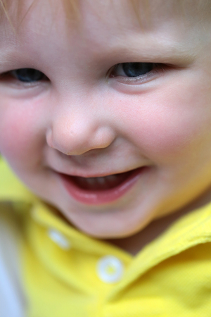 Baby boy smile with blue eyes on happy face and blond hair on natural environment. Child, childhood,...