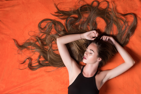 hairdresser, relax, sleep. woman with long hair sleep in bedroom, beauty. woman sleep on floor, perfect morning. Tired girl, fashion, hair salon.の写真素材