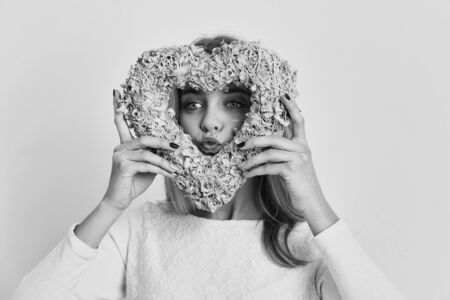 Pretty girl or cute woman with blond hair and adorable happy face in white sweater, blouse or...