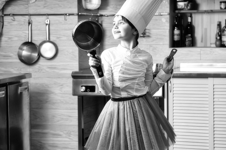 Small girl with pan in cook hat. Cooking, food, studyの写真素材