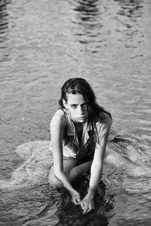 Pretty girl cute beautiful woman in blue dress outdoors in water on natural backgroundの写真素材