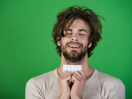 Cold, flu and headache treatment, hypnotic tablet. Health and medicine, hangover. Drug and antidepressant, insomnia. Dieting pill and vitamin, man with anabolic. Man with pills in blister pack.の写真素材