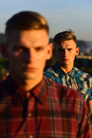 Twin men or handsome, young, male athletes with sexy, muscular torsos outdoors in mountains on blue sky, copy spaceの写真素材