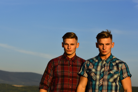 Men twins in sunset or sunrise, friendship. Men twins with athletic body, family values, copy spaceの写真素材