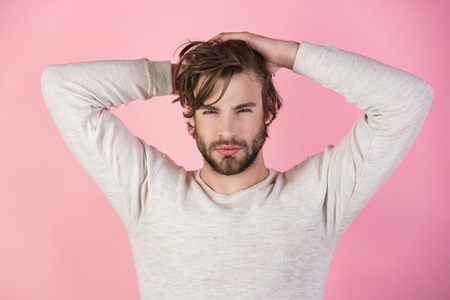 Sleepy man with beard on pink background. Man with disheveled hair in underwear. Barber and hairdresser, male fashion. Morning wake up, everyday life. Insomnia, energy, single with uncombed hair.の写真素材
