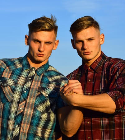 Partnership, future, support and trust. Fashion for men, summer. Twin brothers man outdoor, relations. Men twins in sunset or sunrise, friendship. Man twins with athletic body, family values.の写真素材