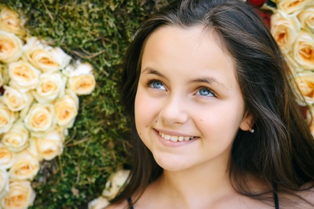 Child pose on floral background, spring, summer season. Child with colorful rose flowers, floristic, floral decor, design, flower shop.の写真素材