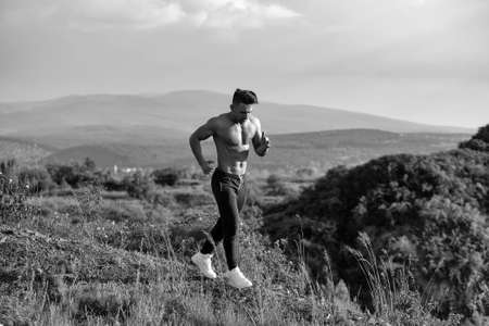 Handsome strong muscular athletic man working out and running outdoors in natureの写真素材