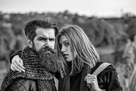 Young happy couple of pretty girl and bearded man hipster embracing outdoors in park on autumn day on natural backgroundの写真素材