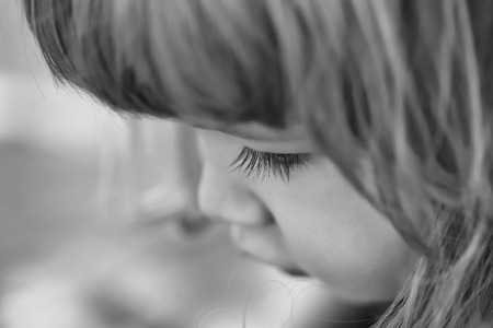 Cute little boy with long eyelashes and blond hair on pretty faceの写真素材