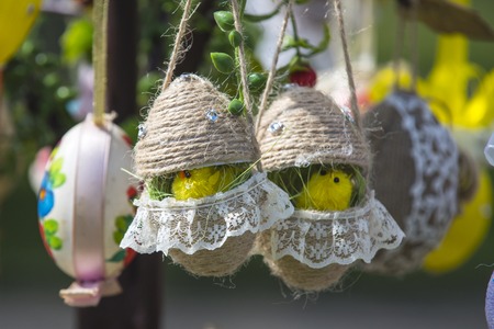 Easter egg chickens hang on spring tree. Easter decoration concept. Handmade eggs with traditional easter design. Happy easter day. Spring holidays celebration.の写真素材