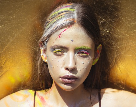 Indian woman with colorful neon paint makeup face. Paint party, colors festival. Holi, indian culture. Visage, make up, body art. Girl beauty, fashion, look.の写真素材