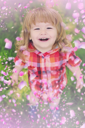 Happy child in flowers . Kid in flowersの写真素材