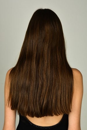 Woman with long brunette hair, back view. Girl with healthy hair, hairstyle. Beauty salon concept. Hair care, hairdresser, shampoo.の写真素材