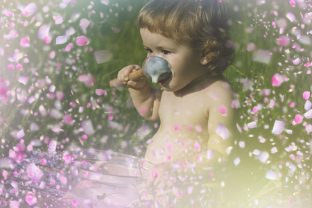 Happy child in flowers . Kid in flowersの写真素材