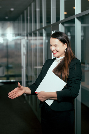 partnership and agile business. Manager girl with happy face hold document. Businesswoman or ceo fashion. Business and success. Woman in formal outfit in glass office.の写真素材