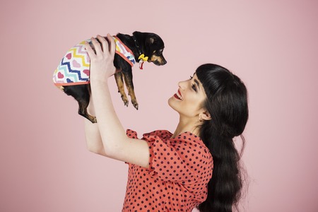 Happiness, positive emotion, smile, holiday, birthday, dog, pet concept. Woman receives present and...