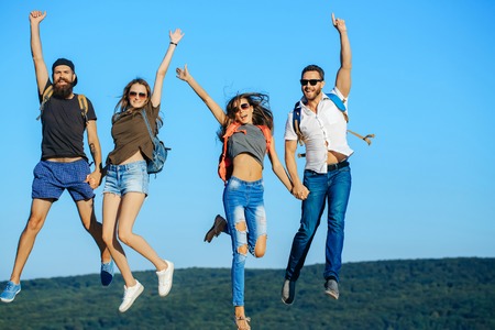 People jump on blue sky, wanderlust. People in mountains on summer vacation.の写真素材