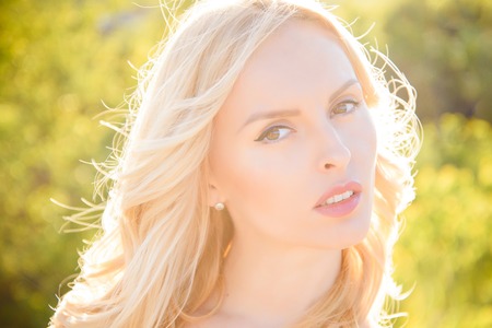 woman in sunny summer weather, hairdresser. Woman with blonde hair outdoor. Girl with sexy red lips, loneliness. Beauty and fashion, look. spa, skincare and cosmetics, makeup.の写真素材