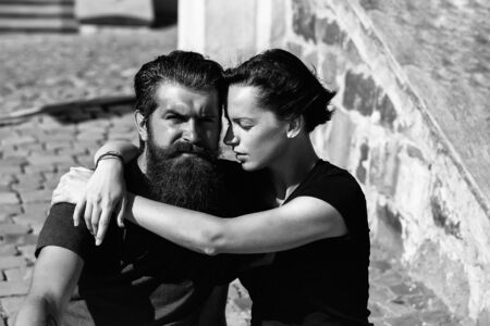 Young couple of beautiful brunette woman and handsome man hipster with beard hug outdoors on sunny dayの写真素材