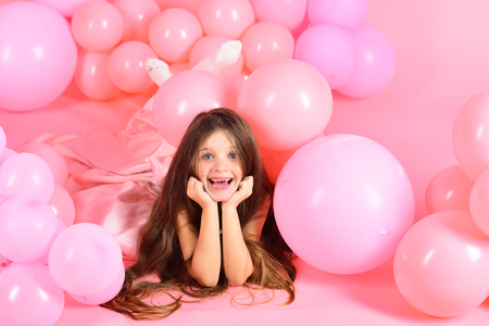little girl on a background of pink balloonsの写真素材
