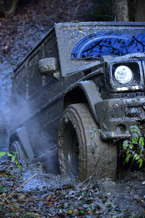 Part of car stuck in dirt, close up. Dirty offroad tire covered with mud.の写真素材