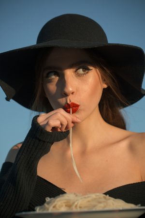 pasta in hands of elegant woman in black hat. pasta as italian traditional foodの写真素材