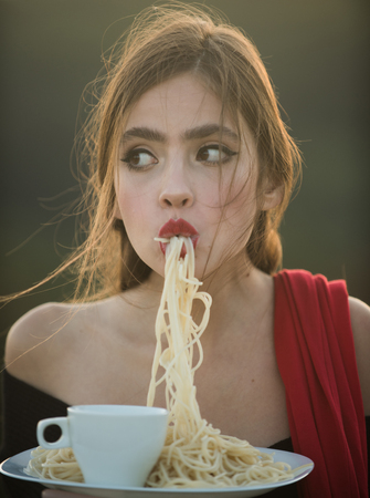 Hunger, appetite, recipe. hunger and appetite of young woman with red lips eating dinnerの写真素材