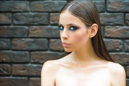 Woman with makeup skin face, bare shoulders, skincare. Woman with wet or oily long brunette hair,...