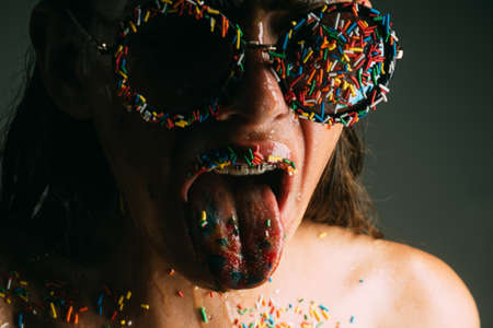 Young woman with sprinkles makeup. Diet and sweet dessert, easter. Makeup of sugar candy kiss on...
