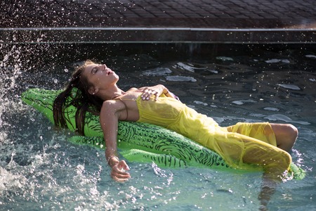 Adventures of girl on crocodile. Relax in luxury swimming pool. Summer vacation and travel to ocean, maldives. Sexy woman on sea with inflatable mattress. Fashion crocodile leather and girl in water.の写真素材