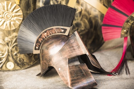 Greek or rome helmet in profile in museum, History, culture, heritage. Helmet made out of metal, copper protection for gladiators in ancient times. Protective helmet with decoration on top.の写真素材