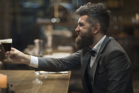 Toast and greeting with a holiday of happy man, smiling bearded man greeting with beer glass at...