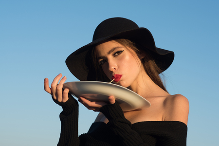 macaroni in hands of elegant woman in black hat. macaroni as italian traditional foodの写真素材
