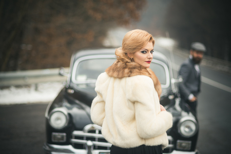 limousine car with driver and sexy lady in fur coat. limousine car in retro style with couple in loveの写真素材