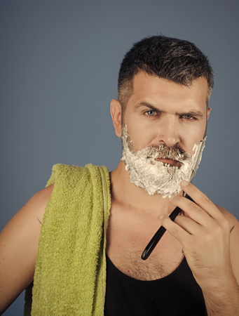 Man cut beard and mustache with razor and shaving brushの写真素材
