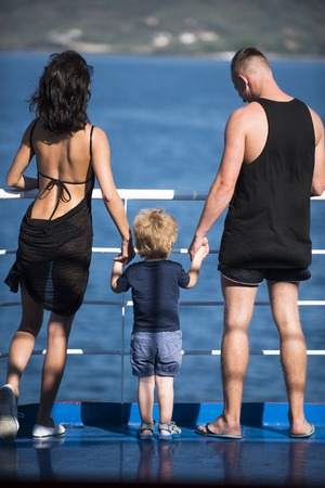 Family travel with kid on mothers or fathers day. Summer vacation of happy family. Child with father and mother. Mother and father with son look at sea on beach. Love and trust as family values.の写真素材