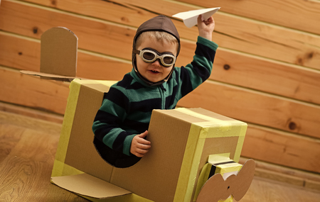 Air mail delivery, aircraft construction. Little boy child play in cardboard plane, childhood. Kid, pilot school, innovation. Pilot travel, airdrome, imagination. Dream career adventure educationの写真素材