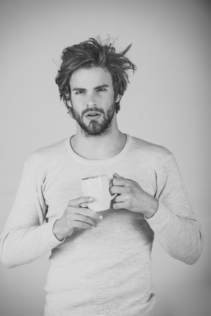 Man with disheveled hair drink mulled wine.の写真素材